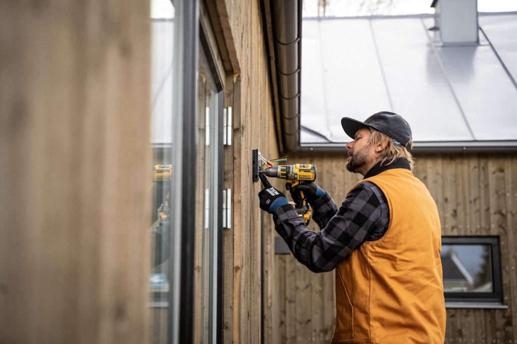 An electrician installs an electrical box with Ten Protection work gloves on.